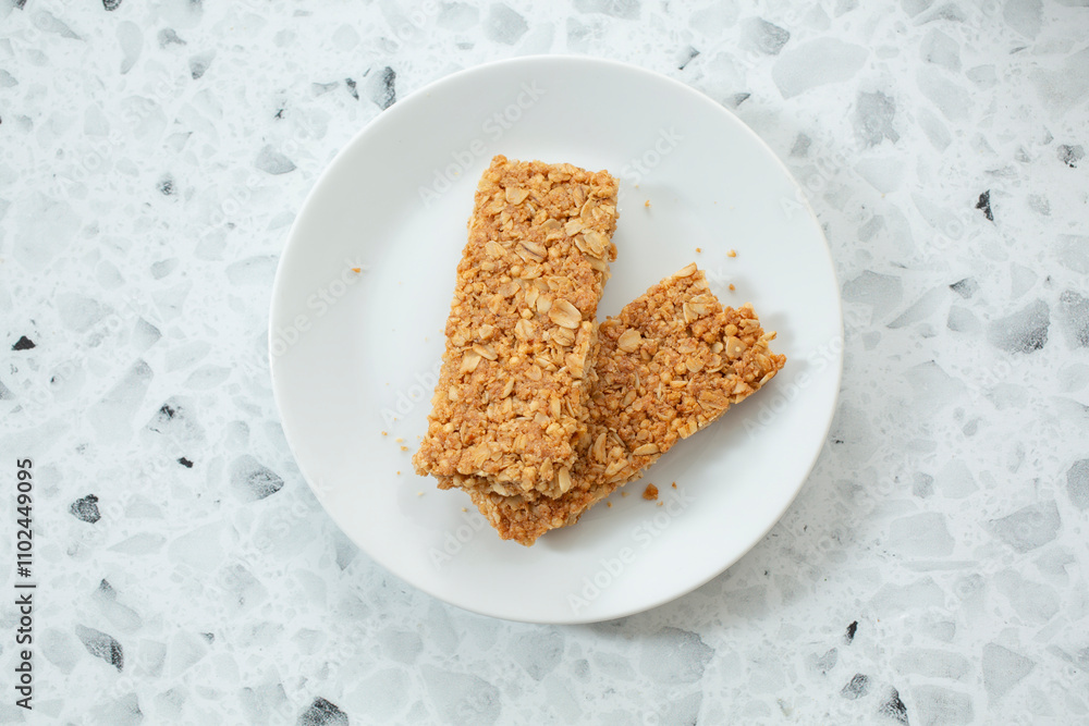 A top down view of a plate of crunchy granola bars. A top down view of a plate of crunchy granola bars.