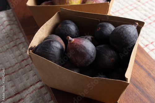 A view of a carton of black mission figs. photo