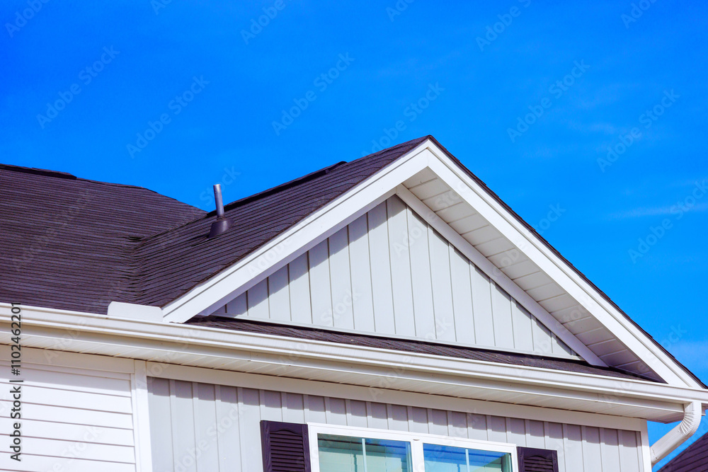 Sloped roof features stylish shingles light colored siding, presenting contemporary architectural design against composition captures sense of tranquility. Sloped roof features stylish shingles light colored siding, presenting contemporary architectural design against composition captures sense of tranquility.