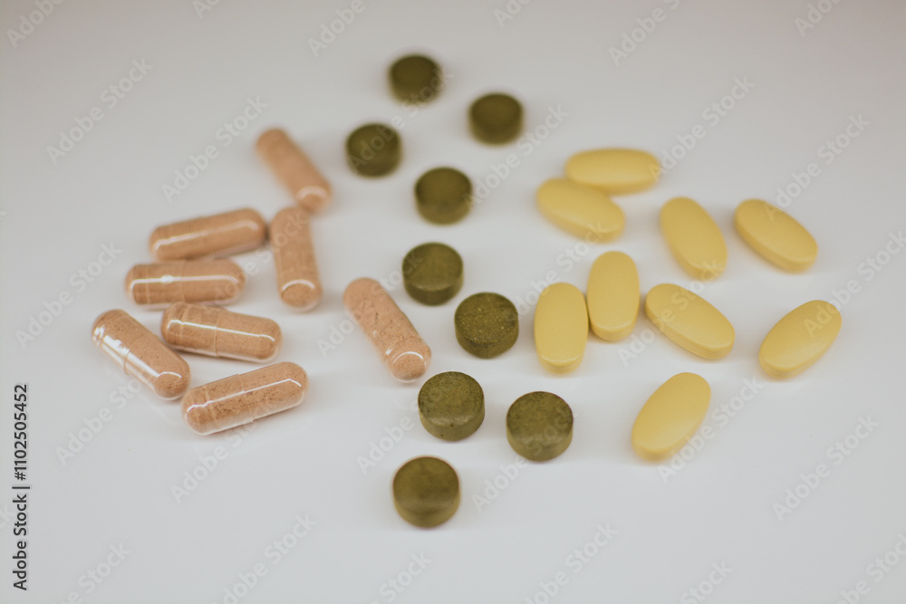 Multi-colored tablets of different shapes with different medical effects on a white background Multi-colored tablets of different shapes with different medical effects on a white background