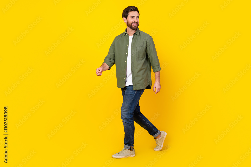 Full length portrait of nice young man walk empty space wear shirt isolated on yellow color background Full length portrait of nice young man walk empty space wear shirt isolated on yellow color background