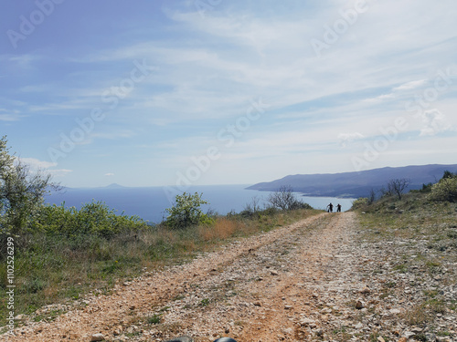 Photography Bicyclists walking uphill on the long stone track at Rabac mtb trail park in eastern istria, croatia