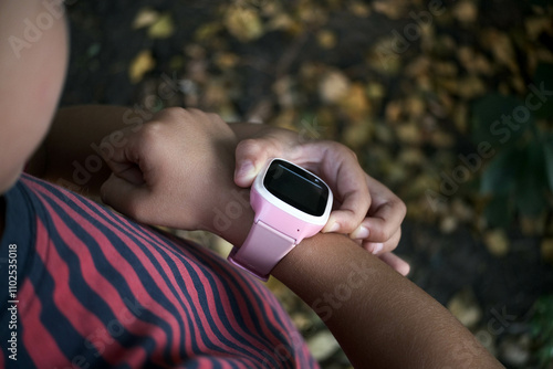 Pink smart watch on the child's hand.