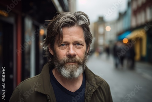 Portrait of a handsome mature man with long gray beard and mustache in the city