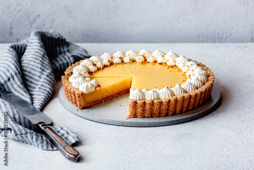 Lemon tart on a plaster surface with piped whipped cream-11 photo