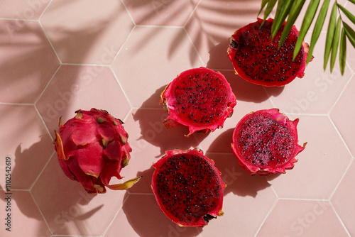 dragon fruit, also known as pitaya, cut open pink magenta-colored flesh with tiny black seeds, tropical fruits