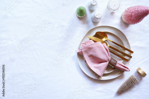 Christmas Dinner Table Setting in Modern Pink, White and Gold Theme. Horizontal Orientation with Negative Space. photo