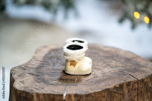 white santa claus boots and toys on tree stump in winter snowy forest . Merry Christmas and happy new year