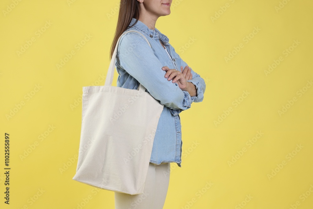 Woman with blank shopper bag on yellow background, closeup. Mockup for design Woman with blank shopper bag on yellow background, closeup. Mockup for design