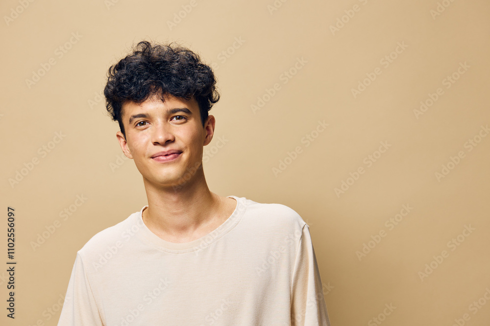 Young man smiling against a light beige background, casually dressed in a plain shirt, conveying a sense of positivity and approachability, perfect for lifestyle and portrait photography Young man smiling against a light beige background, casually dressed in a plain shirt, conveying a sense of positivity and approachability, perfect for lifestyle and portrait photography