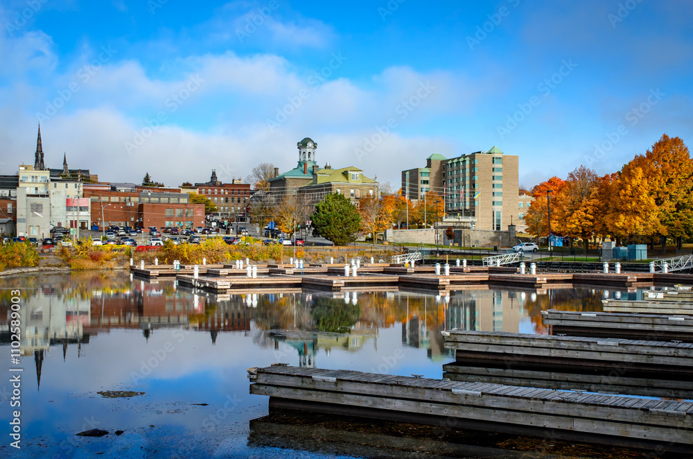 Obraz premium View from the empty marina harbour showing Brockville's city hall and downtown buildings with trees in autumn color,