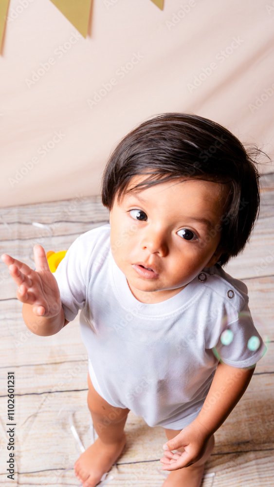 Curious toddler reaching out in wonder during a playful birthday Curious toddler reaching out in wonder during a playful birthday