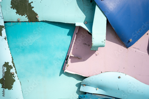 Full frame detailed shot of damaged blue and pink metallic wall outdoors. Closeup of metal sheets nailed on each other to create and wall like structure on a bright sunny day.  photo