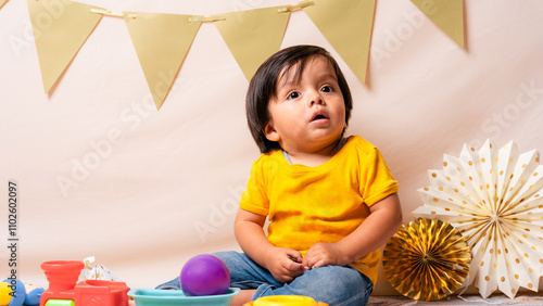 urious toddler surrounded by festive decorations during a colorful birthday party photo