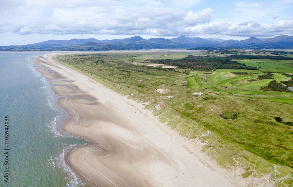 Harlech Beach on Ceredigion Bay, Gwynedd, west Wales. View northwest along sand beach and dunes to mountains of Snowdonia. Aerial
