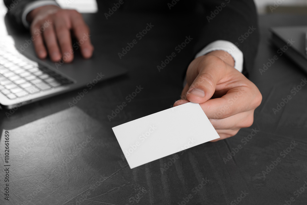 Man holding blank business card at table in office, closeup. Mockup for design Man holding blank business card at table in office, closeup. Mockup for design