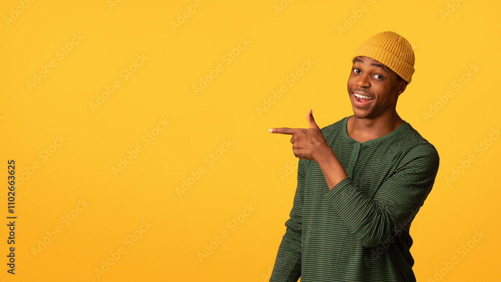 Check This. Cheerful black hipster guy pointing aside at copy space on yellow background, joyful young african american man in stylish hat showing free place for your advertisement, panorama Check This. Cheerful black hipster guy pointing aside at copy space on yellow background, joyful young african american man in stylish hat showing free place for your advertisement, panorama