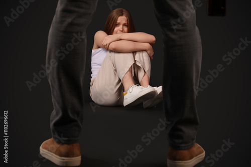Bruised young woman and her...