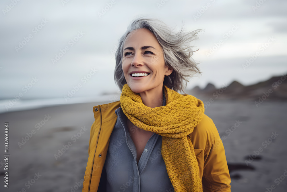 senior woman walking on the beach windy evening. Happy and relaxed caucasian female strolling on the beach. senior woman walking on the beach windy evening. Happy and relaxed caucasian female strolling on the beach.