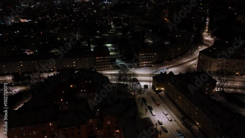 Stunning aerial drone footage captures a snow-dusted city aglow with lights, revealing the urban landscape's beauty after dark. photo