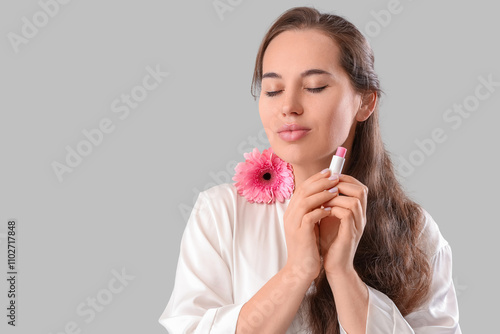 Young woman with lip balm a...