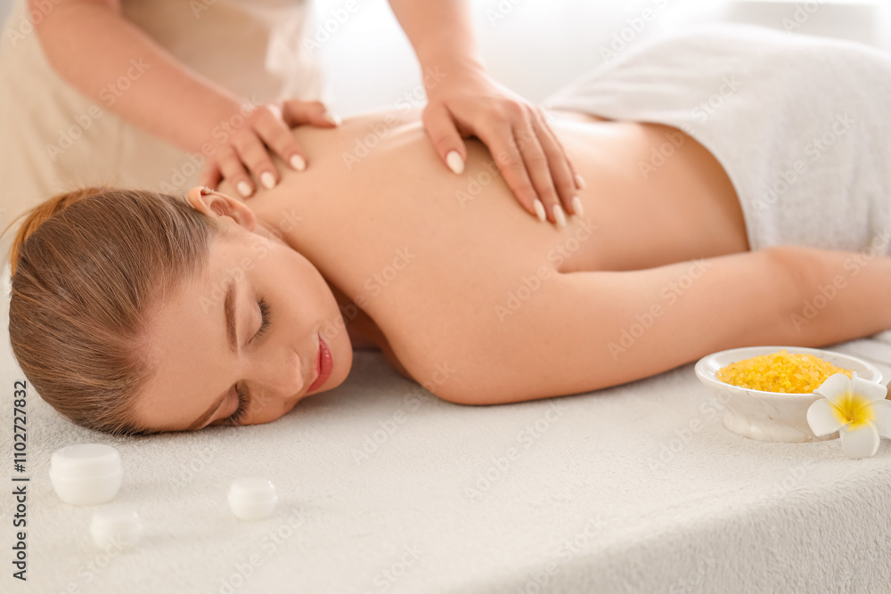 Young woman undergoing massage procedure in spa salon Young woman undergoing massage procedure in spa salon