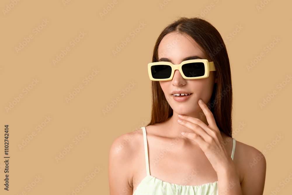Beautiful young woman in stylish sunglasses on brown background Beautiful young woman in stylish sunglasses on brown background
