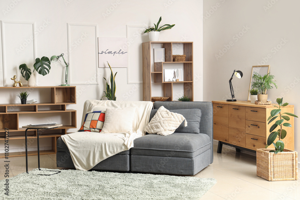 Fototapeta premium Interior of living room with sofa, drawers and shelf units
