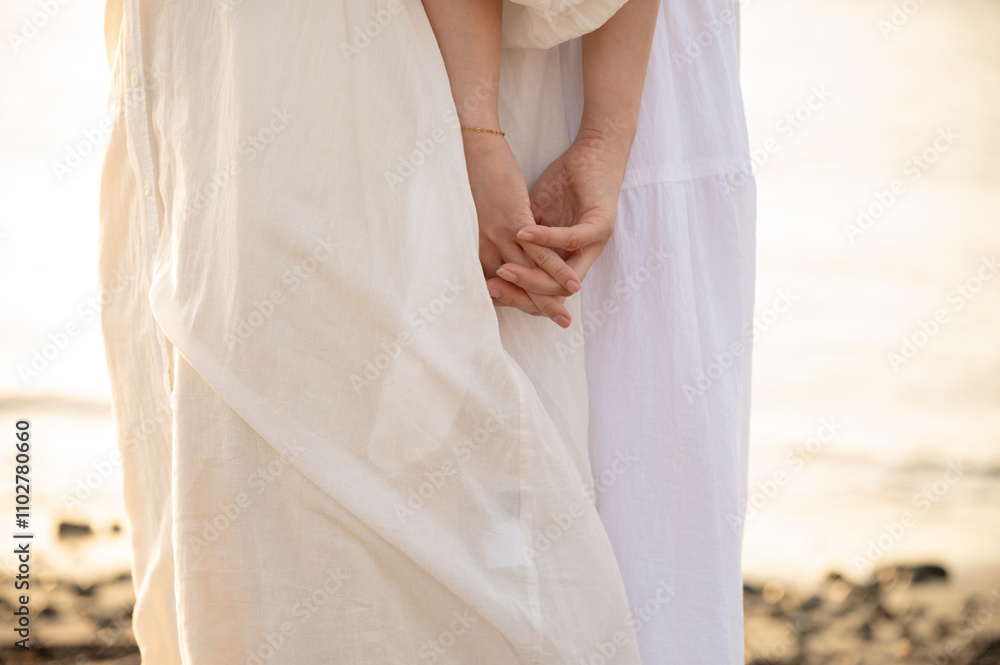 Close-Up of Two Women Holding Hands on the Beach at Sunset Close-Up of Two Women Holding Hands on the Beach at Sunset