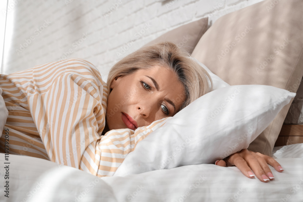 Obraz premium Sad mature woman lying in bedroom, closeup. Menopause concept