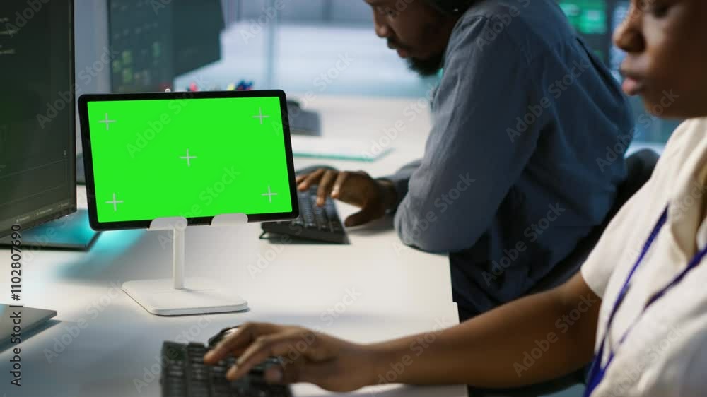 System administrator using isolated screen tablet, working in server farm to optimize it for data processing requirements. Software developer coding on chroma key device in data center, camera A System administrator using isolated screen tablet, working in server farm to optimize it for data processing requirements. Software developer coding on chroma key device in data center, camera A