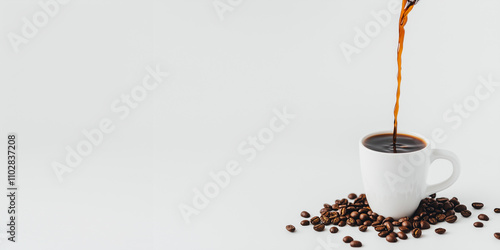 Hot coffee is poured into a white cup with coffee beans scattered beside it, isolated on a white background with copy space
