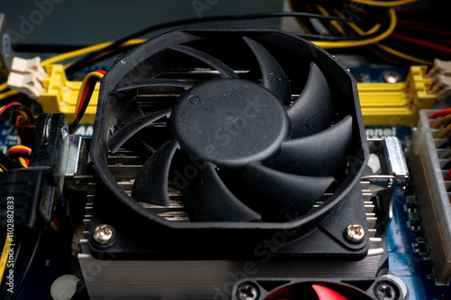 A fragment of a computer motherboard with radiators and fans for cooling