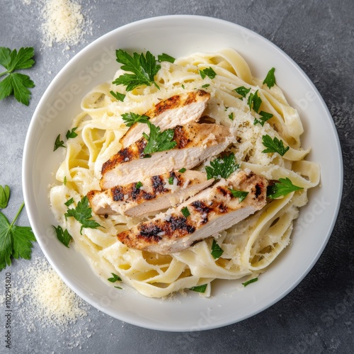 A rich and creamy Alfredo pasta with grilled chicken and a sprinkle of Parmesan cheese, served in a white bowl, Pasta centered