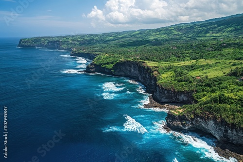 Vivid azure sea swells colliding with dark cerulean depths. Bird’s-eye perspective of tremendous surf impacting rugged coastlines. Warm coastal vistas in summer sunlight