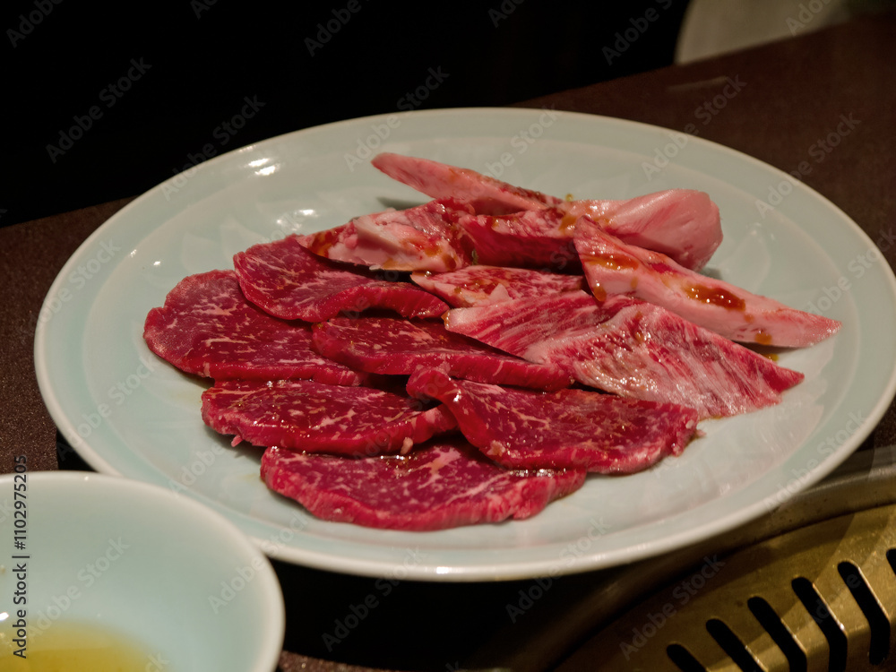 Japanese marbled beef Yakiniku set of raw fatty wagyu meat slices and vegetables on ceramic plate ready for yakiniku grill Japanese marbled beef Yakiniku set of raw fatty wagyu meat slices and vegetables on ceramic plate ready for yakiniku grill