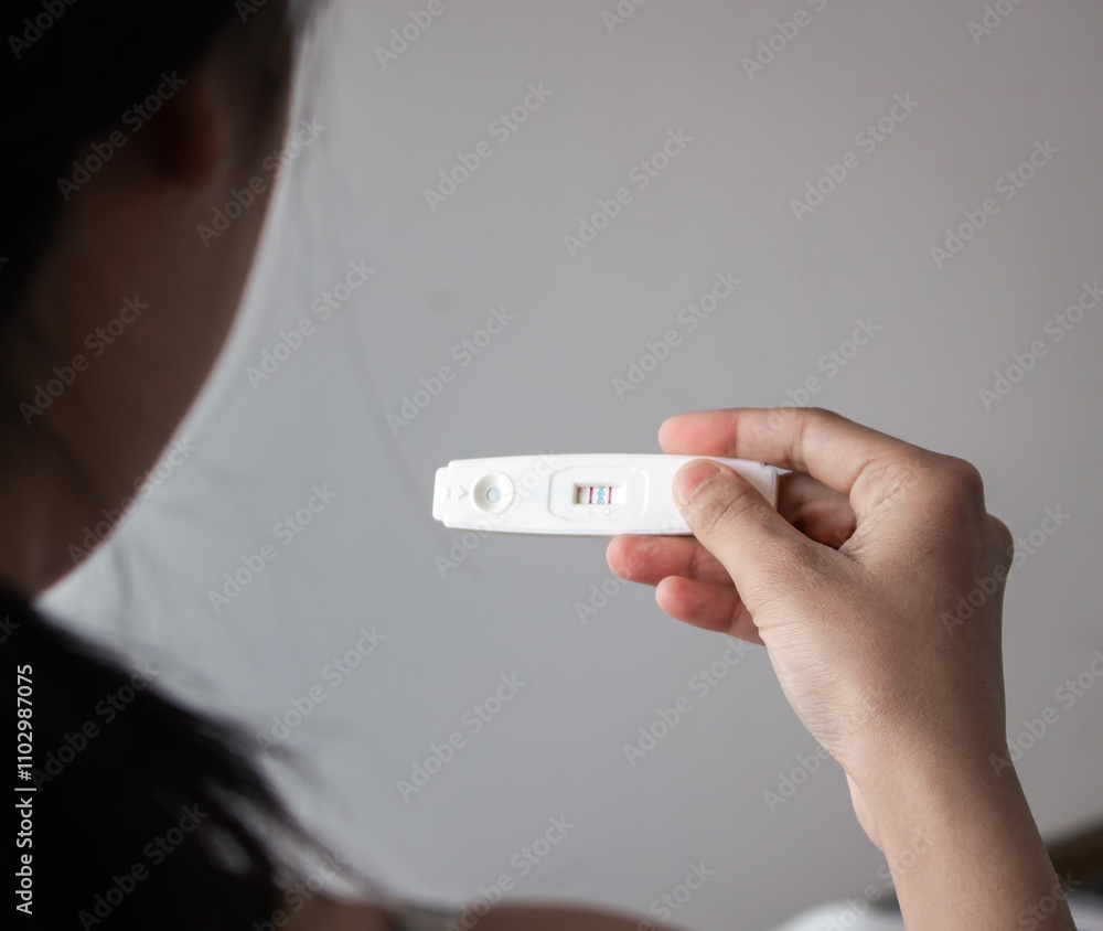 Woman holding a positive pregnancy test in her hand. Selective focus. Woman holding a positive pregnancy test in her hand. Selective focus.