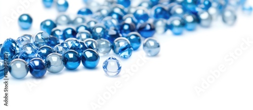 Blue and silver decorative beads scattered on a white background showcasing texture and color variety for crafting and design purposes