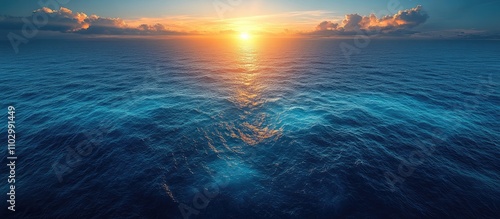 Fototapeta Naklejka Na Ścianę i Meble -  Aerial view of tranquil blue lake at sunset with sunlight reflecting on water surface creating a serene and picturesque landscape scene