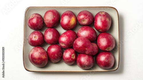 Ripe pitangas beautifully arranged on a square plate showcasing vibrant red colors against a clean white background photo