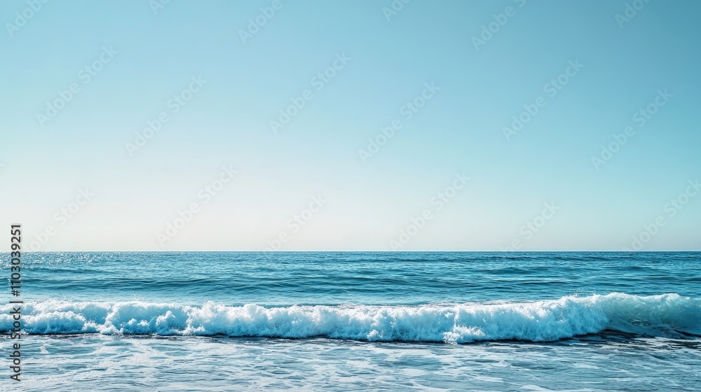 Fototapeta premium Serene Ocean Scene with Gentle Blue Waves Glistening Under a Clear Azure Sky and a Tranquil Horizon