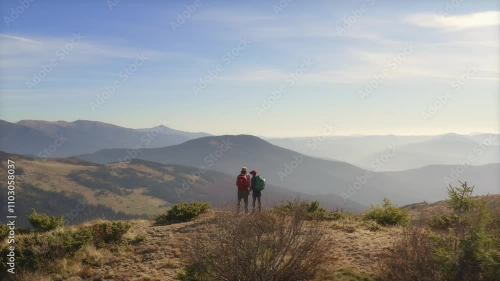 This slow motion drone shot captures hikers enjoying the view from a mountain summit. Ideal for travel advertisements, nature promos, and conceptual footage highlighting adventure and serene This slow motion drone shot captures hikers enjoying the view from a mountain summit. Ideal for travel advertisements, nature promos, and conceptual footage highlighting adventure and serene