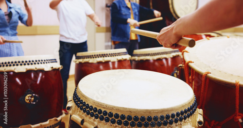 Japanese drums, hands and people with sticks on instrument for stage practice, performance or talent. Taiko, class and drummers in band to play in rehearsal for culture, song rhythm or creative beat photo