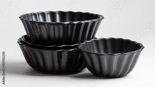 A set of three black fluted bowls arranged in a stylish way, perfect for serving food or as decorative kitchenware. photo