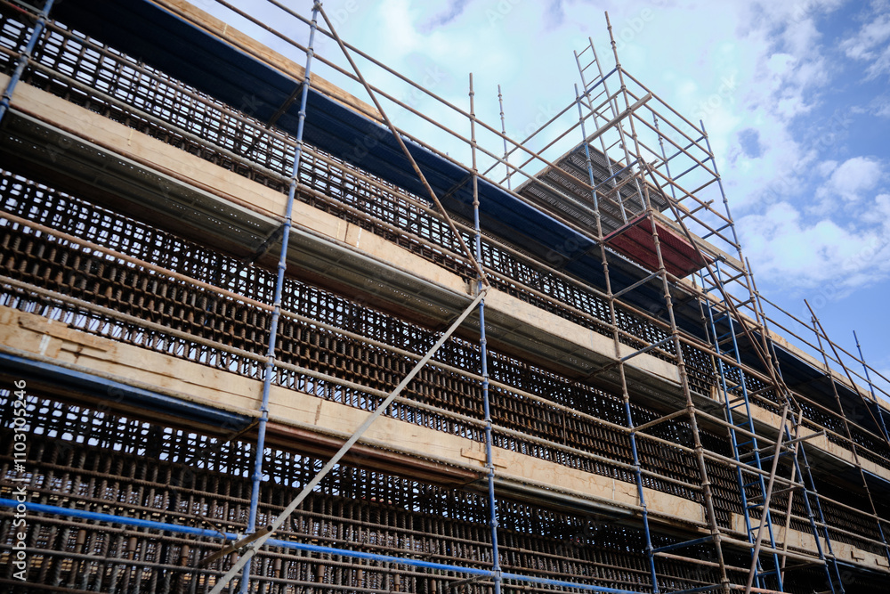 Low angle view of industrial stair tower, scaffoldings and reinforcement frame of walls at construction site Low angle view of industrial stair tower, scaffoldings and reinforcement frame of walls at construction site