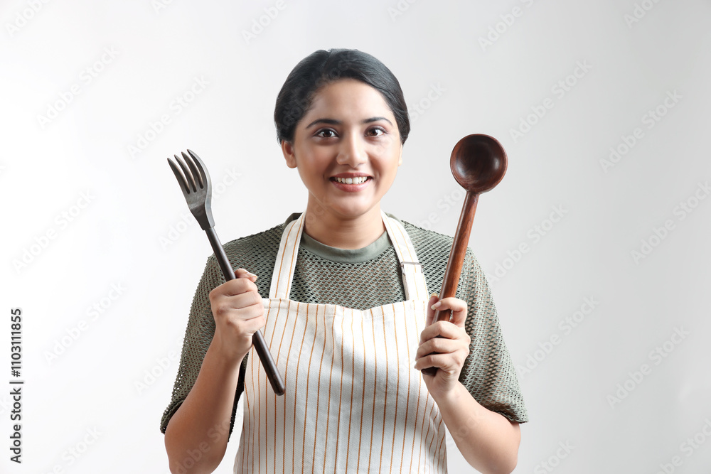 indian Young woman enjoy cooking healthy food in the kitchen at home. holding cooking ware and smiling. indian Young woman enjoy cooking healthy food in the kitchen at home. holding cooking ware and smiling.