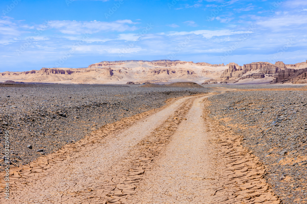 Desert dirt road and mountain natural landscape in Xinjiang, China. Road trip in no man's land. Outdoor natural background. Desert dirt road and mountain natural landscape in Xinjiang, China. Road trip in no man's land. Outdoor natural background.
