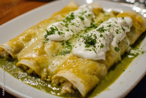 Mexican enchiladas verdes with soft corn tortillas filled with shredded chicken, topped with green salsa, melted cheese, and sour cream. Food Photography, Menu Style Photo Image, close up