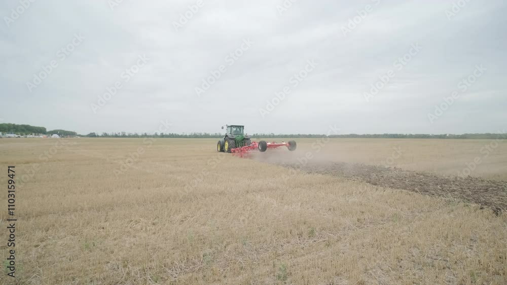 Demonstration of agricultural machinery at an exhibition. Tractors operate in the field, showcasing their capabilities and performance in action Demonstration of agricultural machinery at an exhibition. Tractors operate in the field, showcasing their capabilities and performance in action