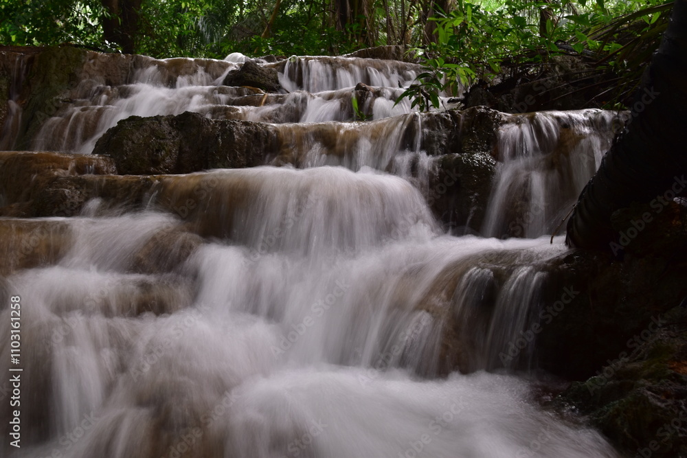 Fototapeta premium Travel to waterfalls during the rainy season, The tiers of the waterfall contrast beautifully with the sky